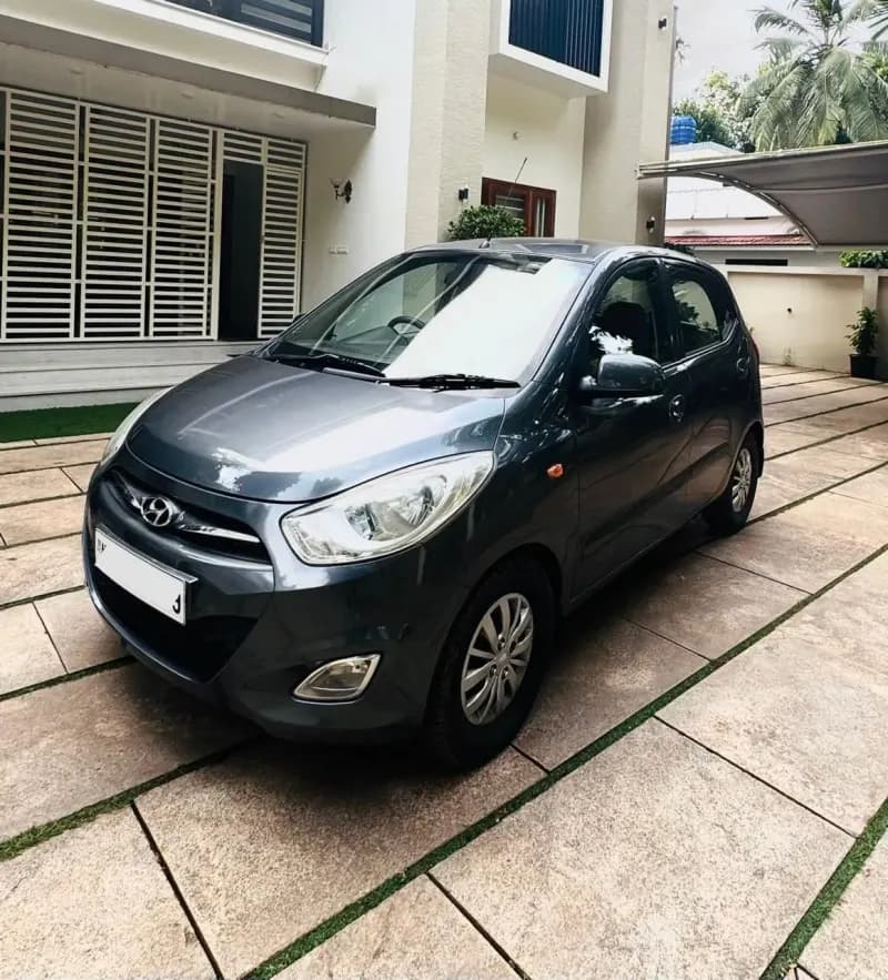 Used 2015 Hyundai i10 Sportz petrol in grey, front three-quarter view, for sale at Car City, Mattanur, Kannur
