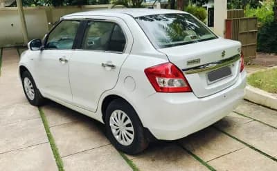 2016 Maruti Suzuki Swift Dzire VXi petrol in white, rear three-quarter view from the left – Car City, Mattanur, Kannur