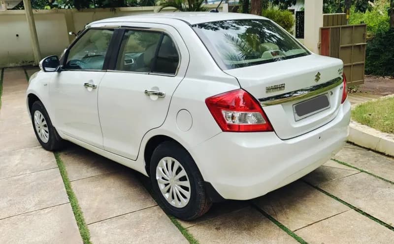 2016 Maruti Suzuki Swift Dzire VXi petrol in white, rear three-quarter view from the left – Car City, Mattanur, Kannur
