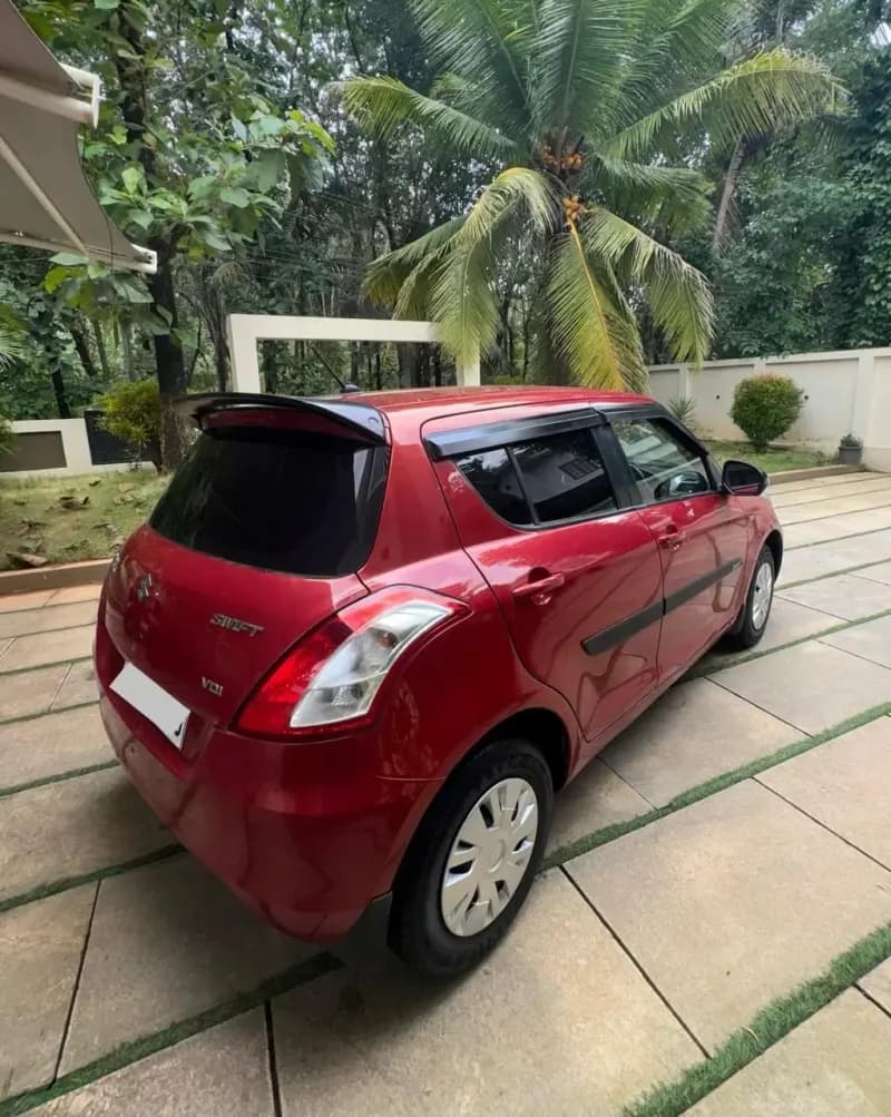 2012 Maruti Suzuki Swift VDi diesel in red, rear three-quarter view with VDi badge – Car City, Mattanur, Kannur